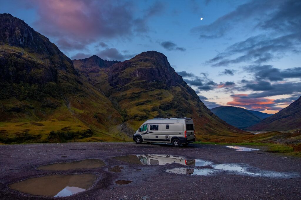 Camperbus in de bergen bij het zonsondergang