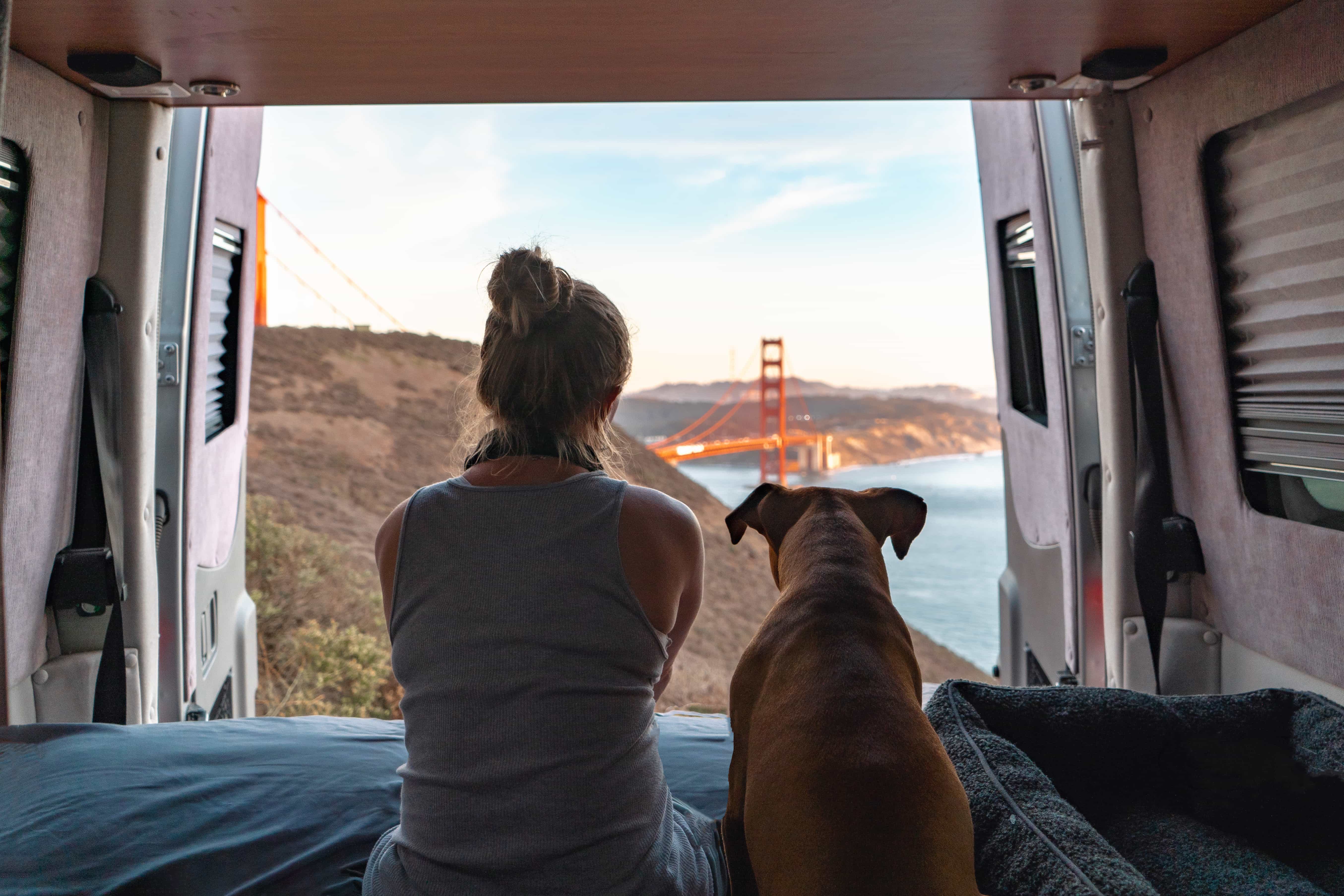 camper verhuren aan hond en vrouw die kijken naar de golden gate brug